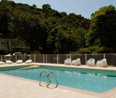 Piscine extérieure avec transats et arbres en arrière plan au Camping VAL FLEURI ATC Cagnes-Sur-Mer