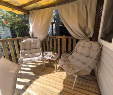 Terrasse en bois avec deux fauteuils et table au Camping Valras les sables du midi