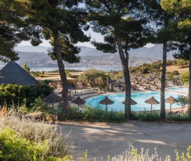 Bord de piscine avec parasols et vue sur la mer au Camping Vigna Maggiore