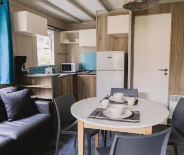 Séjour avec coin cuisine et table dressée dans le mobil home du Camping ZELAIA
