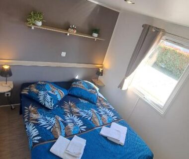 Chambre double avec lit et serviettes dans le mobil home 6 pers du Camping à Condrieu