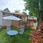 Terrasse et jardin avec table et parasol au mobil home 6 pers du Camping à Condrieu