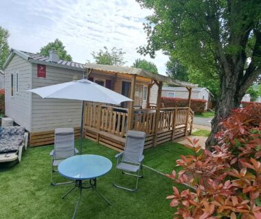 Terrasse et jardin avec table et parasol au mobil home 6 pers du Camping à Condrieu