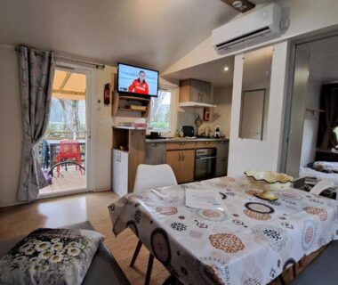 Intérieur de mobil-home avec coin repas et kitchenette au Camping à Condrieu Mobil home 6 pers