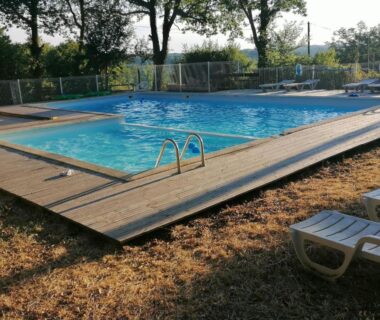 Piscine extérieure avec transats sur deck en bois en Dordogne au Camping au calme