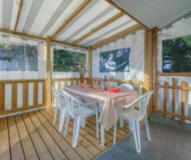 Véranda couverte avec table et chaises au Camping de Brouël