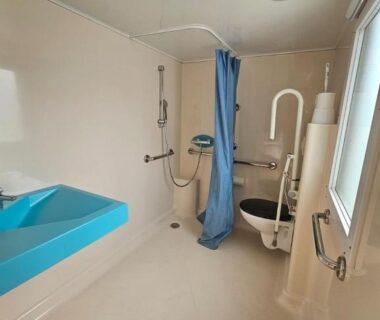 Salle de bain accessible avec douche lavabo et barres d'appui dans le Camping de Charlieu