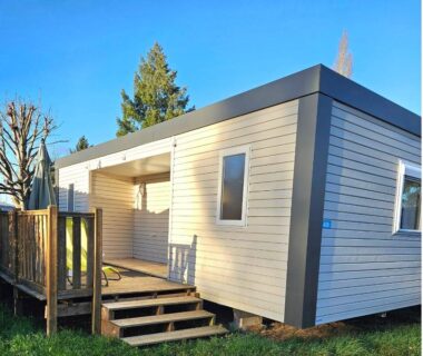 Terrasse et façade d'un mobil-home sur pelouse au Camping de Charlieu