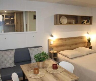 Intérieur mobil-home lit et coin repas au Camping de Charlieu