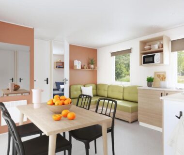 Salon et coin repas lumineux avec kitchenette dans l'hébergement du Camping de Graniers