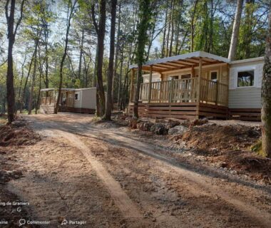 Allée boisée et mobil homes avec terrasses dans le Camping de Graniers