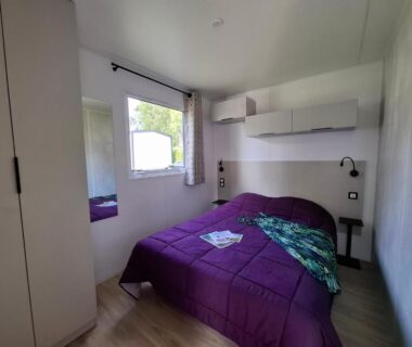 Chambre avec lit double et fenêtre au Camping de La Piscine
