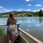 Terrasse en bois au bord du lac avec une personne contemplant au Camping de Matour – ONLYCAMP