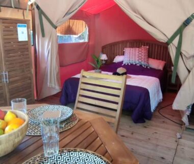 Intérieur de tente avec lit et coin repas au Camping de Matour ONLYCAMP