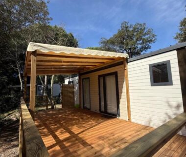 Terrasse en bois couverte par une pergola du mobil-home au Camping de Parpaillon
