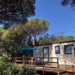 Terrasse en bois avec parasol et mobil-home au Camping de Parpaillon