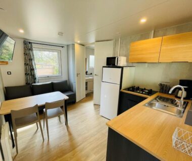 Intérieur kitchenette coin repas et salon lumineux dans le mobil-home du Camping de Parpaillon