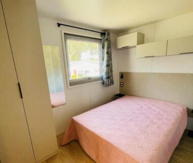 Chambre avec lit double armoire et fenêtre au Camping de Parpaillon