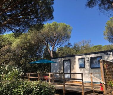 Terrasse en bois avec parasol et mobil-home au Camping de Parpaillon