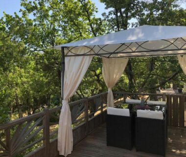 Terrasse en bois avec tonnelle et salon extérieur dans le Camping de Parpaillon