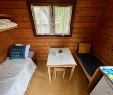 Intérieur du chalet avec lits et table au Camping de Saulieu