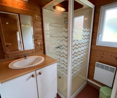 Salle de bain avec cabine de douche et lavabo dans le mobil-home du Camping de Saulieu