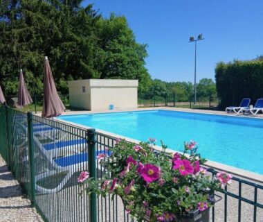 Piscine extérieure bordée de fleurs au Camping de Saulieu