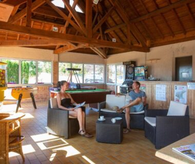 Espace détente couvert avec fauteuils et table basse au Camping de Saulieu