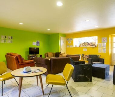 Salle commune avec canapés fauteuils et télévision au Camping de Saulieu