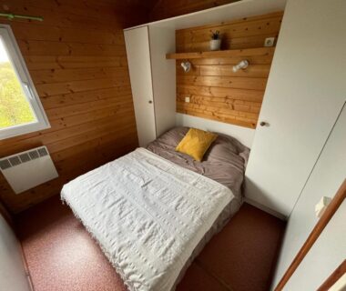 Chambre en bois avec lit double au Camping de Saulieu