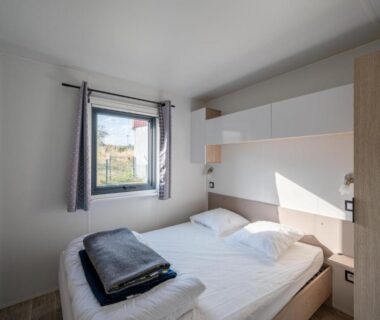 Chambre avec lit double et fenêtre au Camping de Saverne