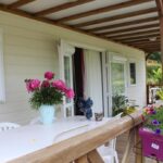 Terrasse couverte avec table et fleurs au Camping de Trezulien