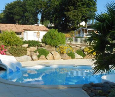 Piscine extérieure avec toboggan et chalets en arrière plan au Camping de Trezulien