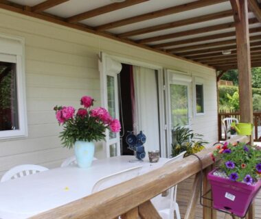 Terrasse couverte avec table et fleurs au Camping de Trezulien
