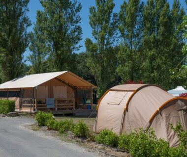 Emplacement avec tente et bungalow sous arbres au Camping de Trezulien
