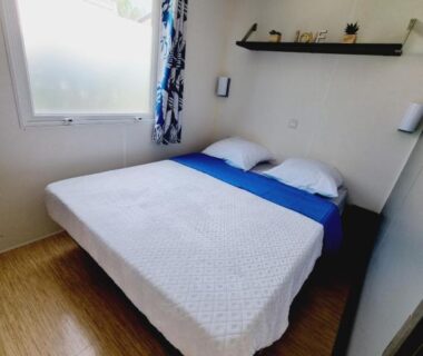 Chambre avec lit double et fenêtre dans le mobilhome Esprit Zen R26 au Camping de l Orangerie de Lanniron