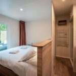 Chambre avec lit et salle de bain au Camping de l'Orangerie de Lanniron