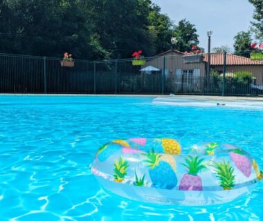 Piscine avec bouée gonflable et eau bleue au Camping de la Bageasse