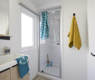 Salle de bain avec cabine de douche et lavabo au Camping de la Baie de Térénez
