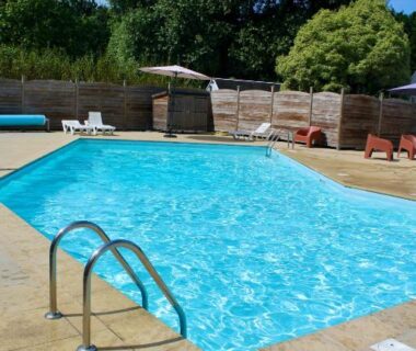 Piscine extérieure avec échelle et chaises longues au Camping de la Baie de Térénez