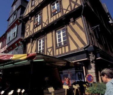 Rue de marché avec étals et maison à colombages au Camping de la Baie de Térénez