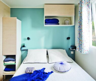 Chambre double lumineuse avec lit et rangements dans le Camping de la Baie de Térénez
