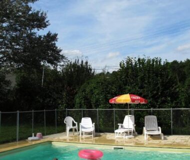 Piscine extérieure avec baigneurs et transats au Camping de la Bonnette