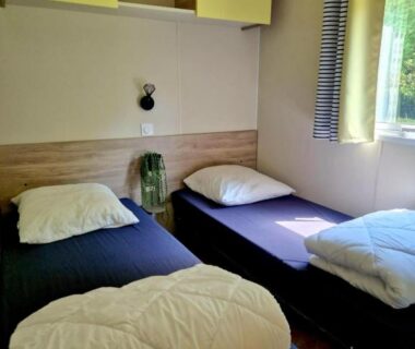 Chambre de mobil-home avec deux lits simples au Camping de la Bonnette