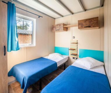 Chambre avec deux lits simples et fenêtre dans le camping de la Dune Les Flots Bleus