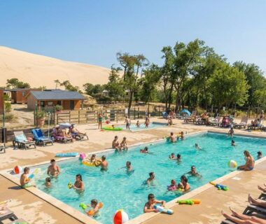 Piscine extérieure avec transats et baigneurs au Camping de la Dune Les Flots Bleus
