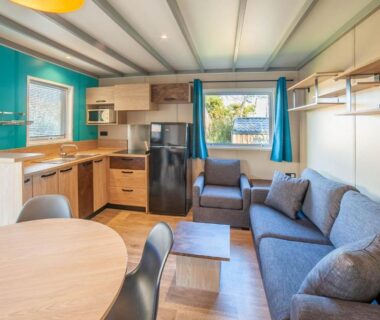 Intérieur du mobil home avec kitchenette et canapé au Camping de la Dune Les Flots Bleus