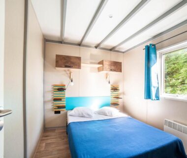 Chambre avec lit double et fenêtre au Camping de la Dune Les Flots Bleus