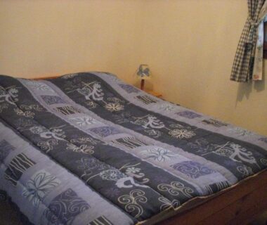 Chambre avec lit et lampe au Camping de la Pelouse