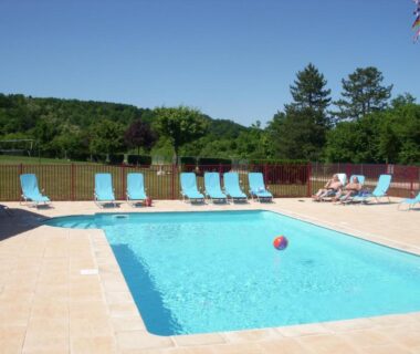 Piscine extérieure avec transats au Camping de la Pelouse